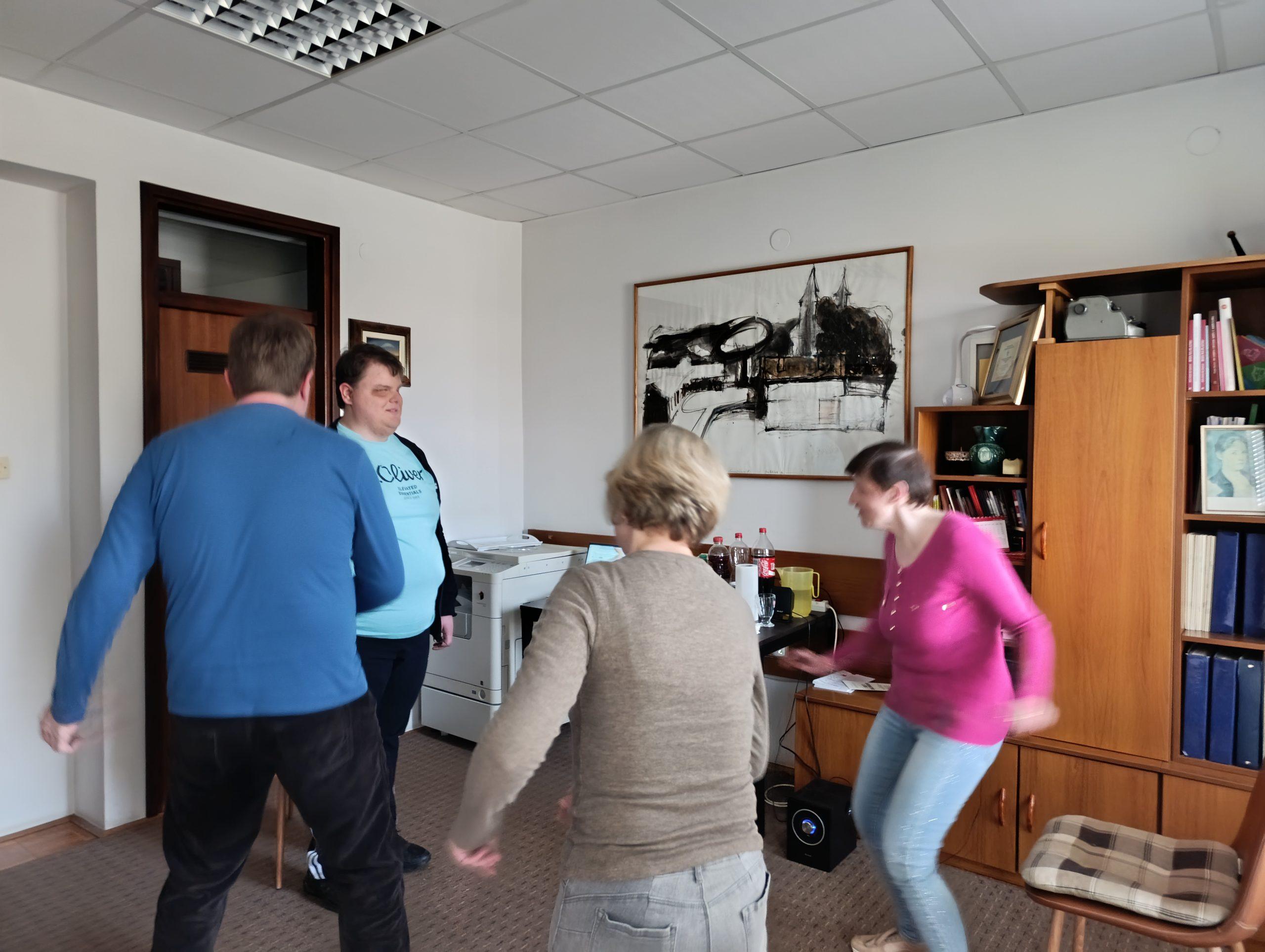 Članovi Udruge slijepih vježbaju i plešu u krugu uz voditeljicu radionice.