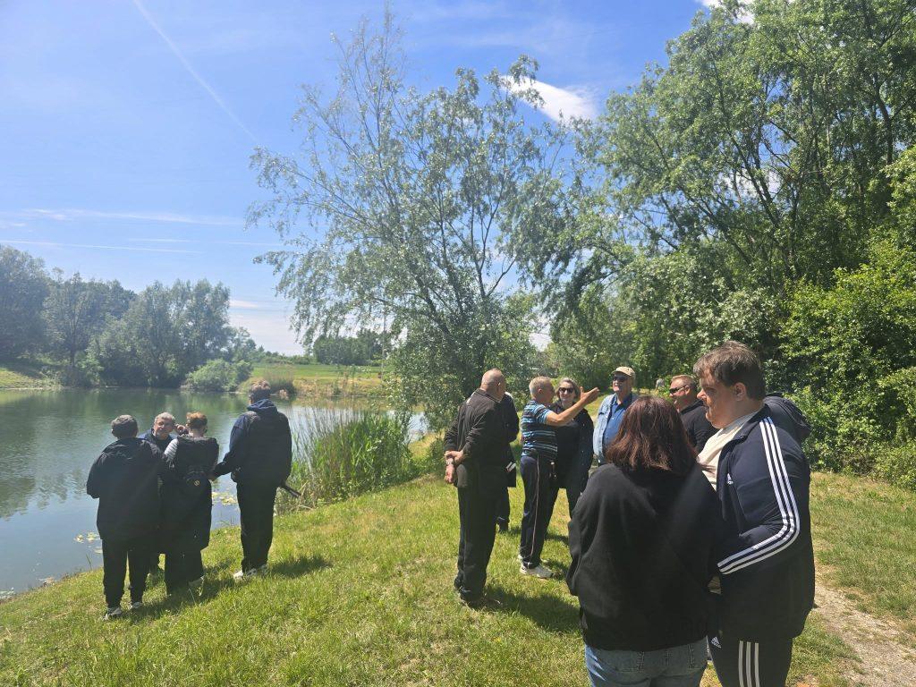 Članovi se druže i razgovaraju pored jezera